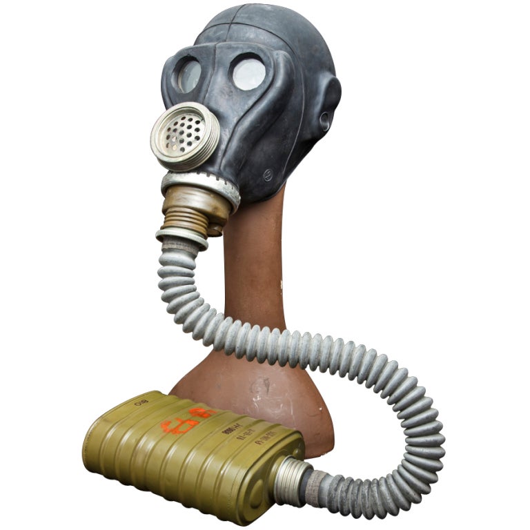 Gas mask with a single hose going to a ribbed canister, included is a female mannequin head