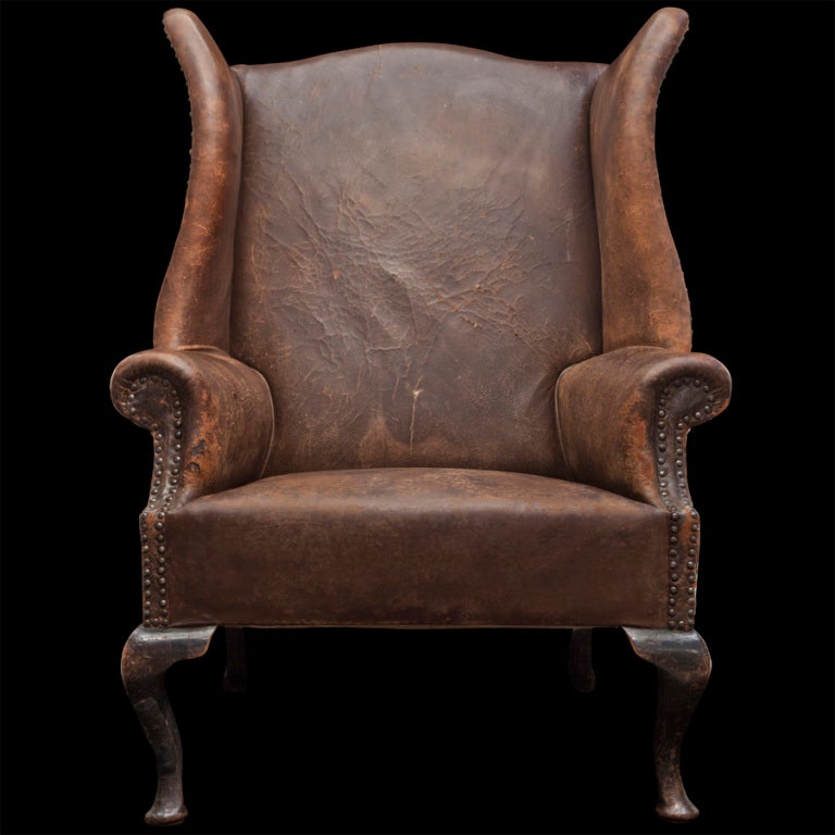 Wonderfully worn leather armchair with exaggerated proportion