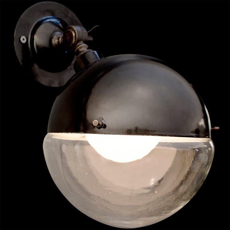 Rounded glass and metal wall mounted sconce, black top with half round circle shade