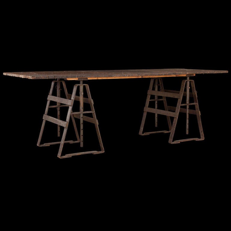 Primitive trestle table with wooden top, and adjustable iron legs, maximum height of 34