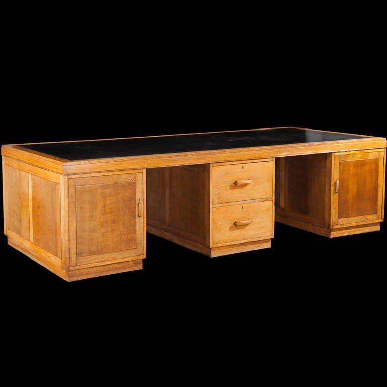 Incredible oak partners desk, with leather top and compartmentalized storage.

Manufactured in England circa 1940.