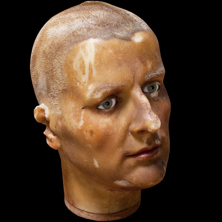 Lifelike male head / face, likely a mannequin head, glass eyes
  