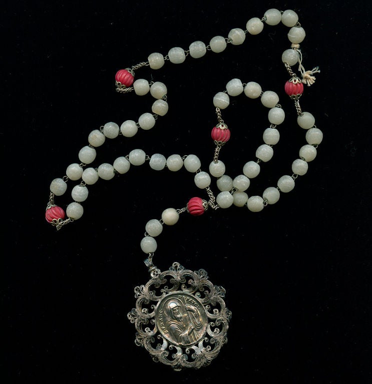 Rosary with two male Patron Saints on either side of medallion, silver filigree, off white and rose colored beads.
