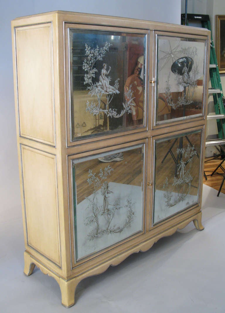 A beautiful 1940s cabinet with exceptional details including a carved scrolled base, raised and detailed panels and Lucite door pulls. Each of the four doors is fitted with a reverse painted glass panel with an Asian garden scene and each panel was