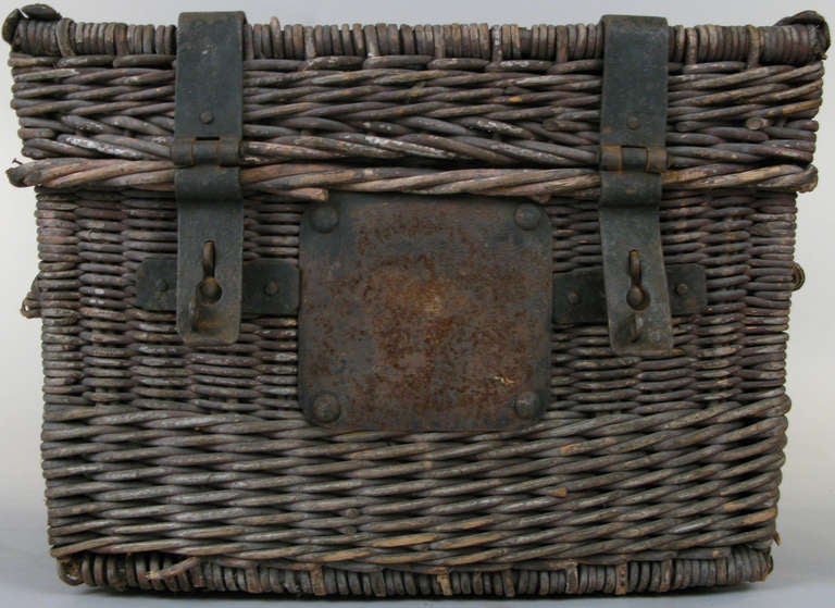 a handsome antique trunk made from woven rattan, with forged iron straps and locks. one rattan handle damaged.