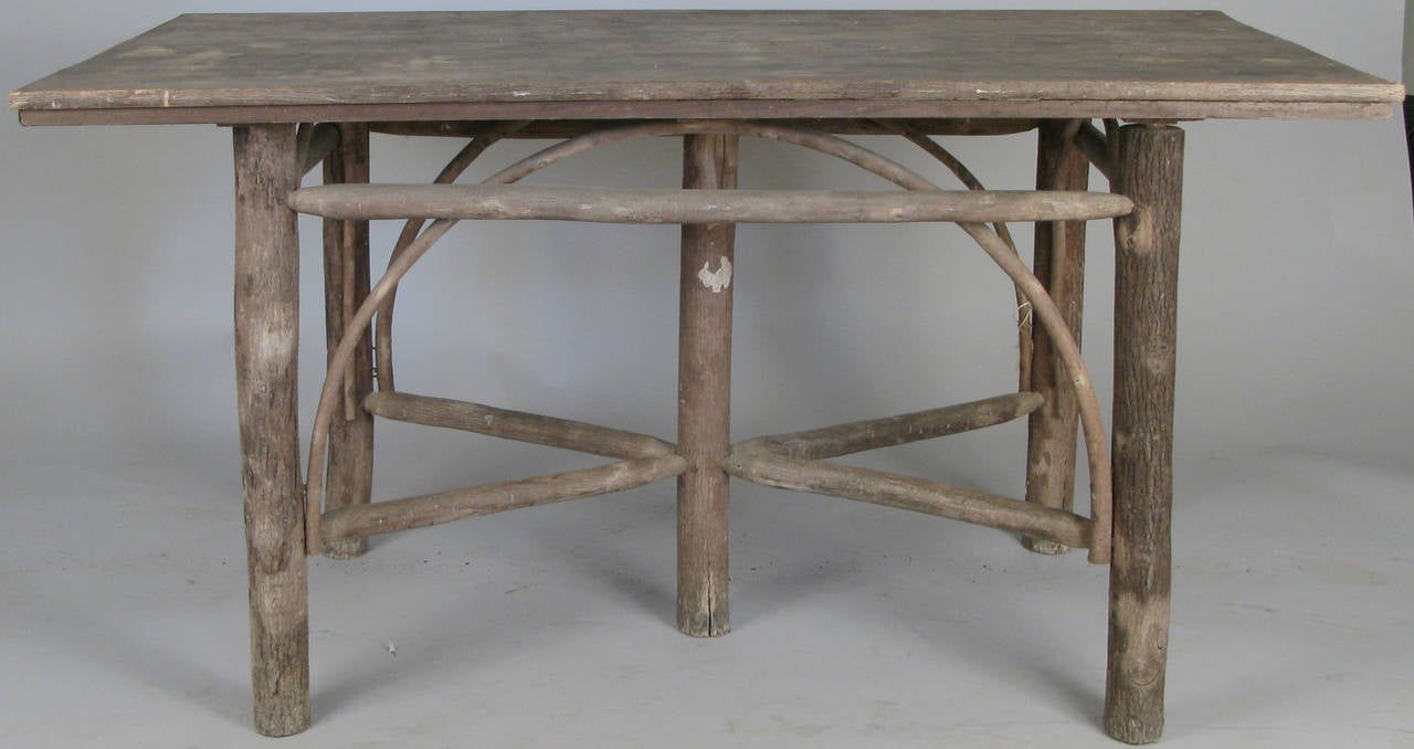 a very handsome antique 1920's adirondack table, with branch legs and curved stretchers. original finish, very nice perfectly symmetrical design.