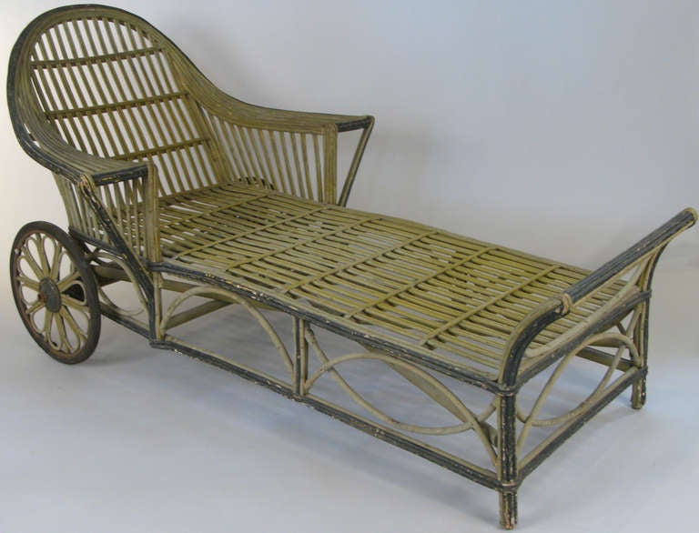 a beautifully designed antique 1930's rolling wicker chaise lounge, in original condition with long seat and curved sculptural arms. in original condition.