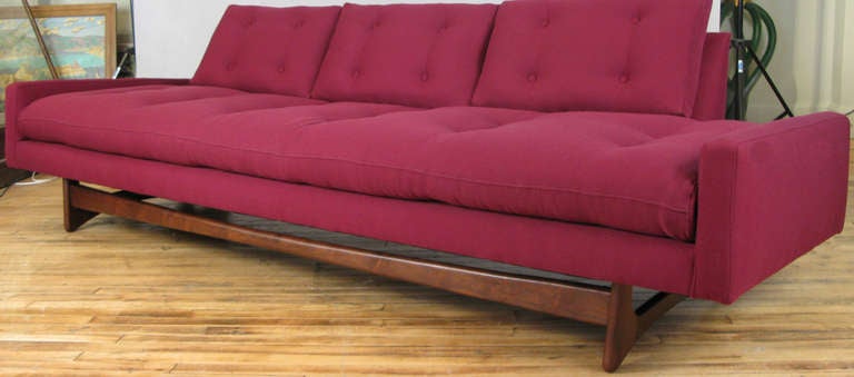 a classic mid-century modern sofa designed by Adrian Pearsall for Craft Associates. one of his best designs, with a long seat and back with tufted cushions. raised on a sculptural walnut base. newly upholstered in a textured cotton. fabric samples