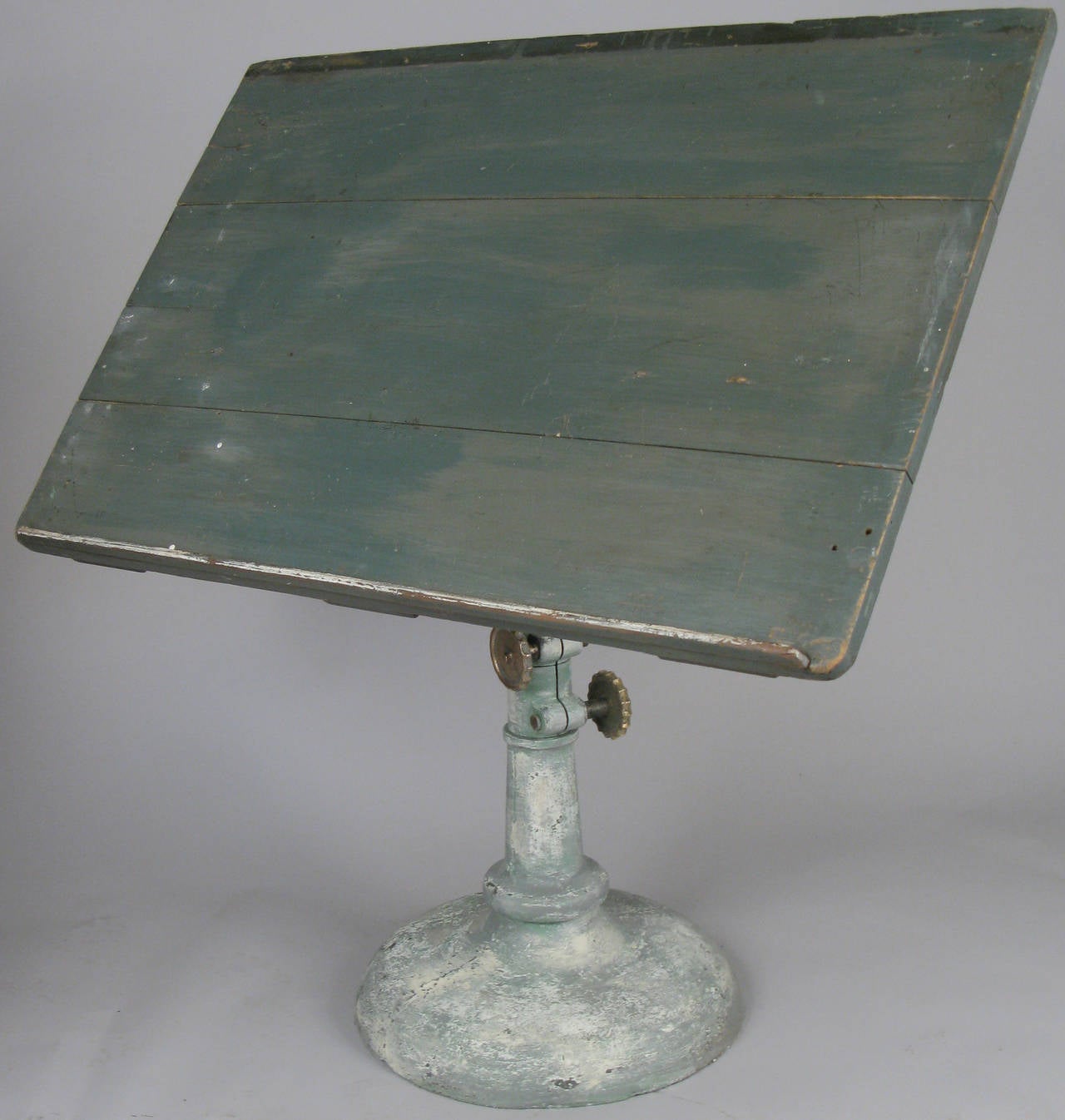 An exceptional early 20th century cast iron pedestal base drafting table. Outstanding base with large solid bronze adjustment discs and very nice details, height and tilt adjustable. Large original wood top.
