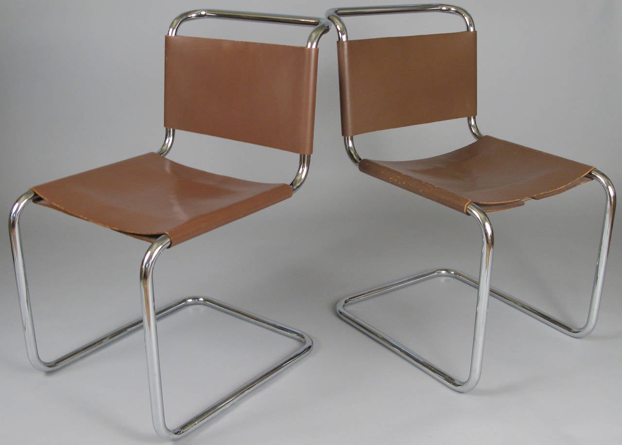 A very handsome pair of vintage 1950s Italian chairs with chromed steel cantilevered frames and saddle leather seats and backs in dark caramel. Beautiful Classic spare modern design, very well made.