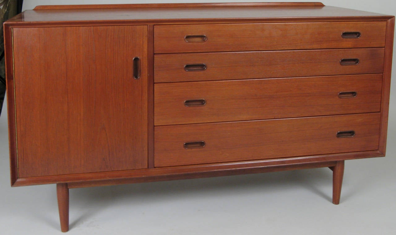 A beautiful Mid-Century Danish teak sideboard designed by Arne Vodder, with a door on the left and four graduated and divided drawers on the left. Beautiful finish and in excellent condition.