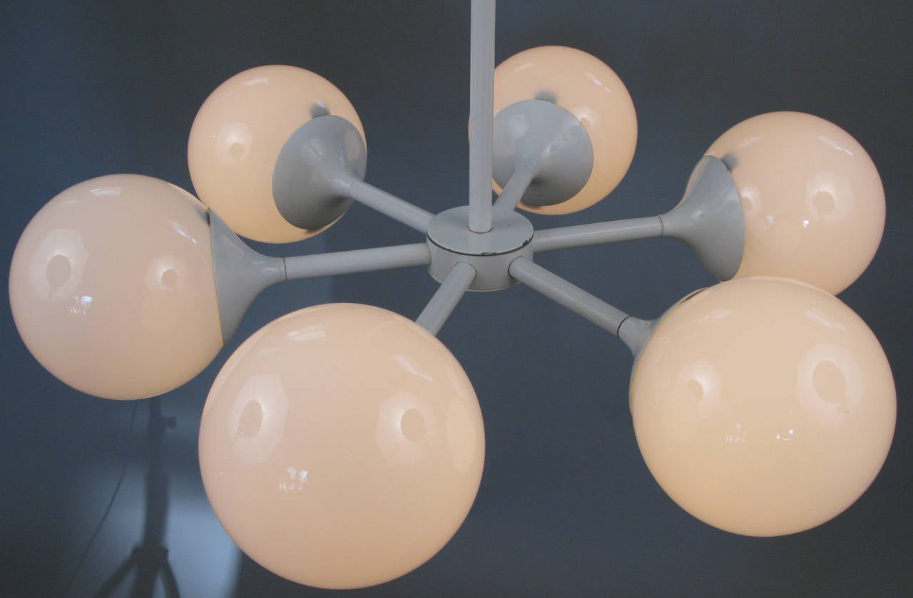 A vintage 1950s modern hanging chandelier by Lightolier, in the style of Max Bill, with six enameled steel arms each with a round white glass globe.