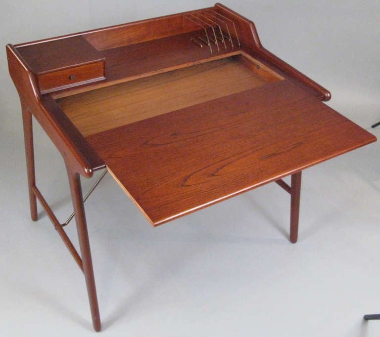 a beautiful vintage 1950's danish teak writing desk designed by Svend Madsen. the locking writing surface slides forward to access the interior of the desk, allowing the work to be undisturbed. charming details with a small drawer upper left, and a
