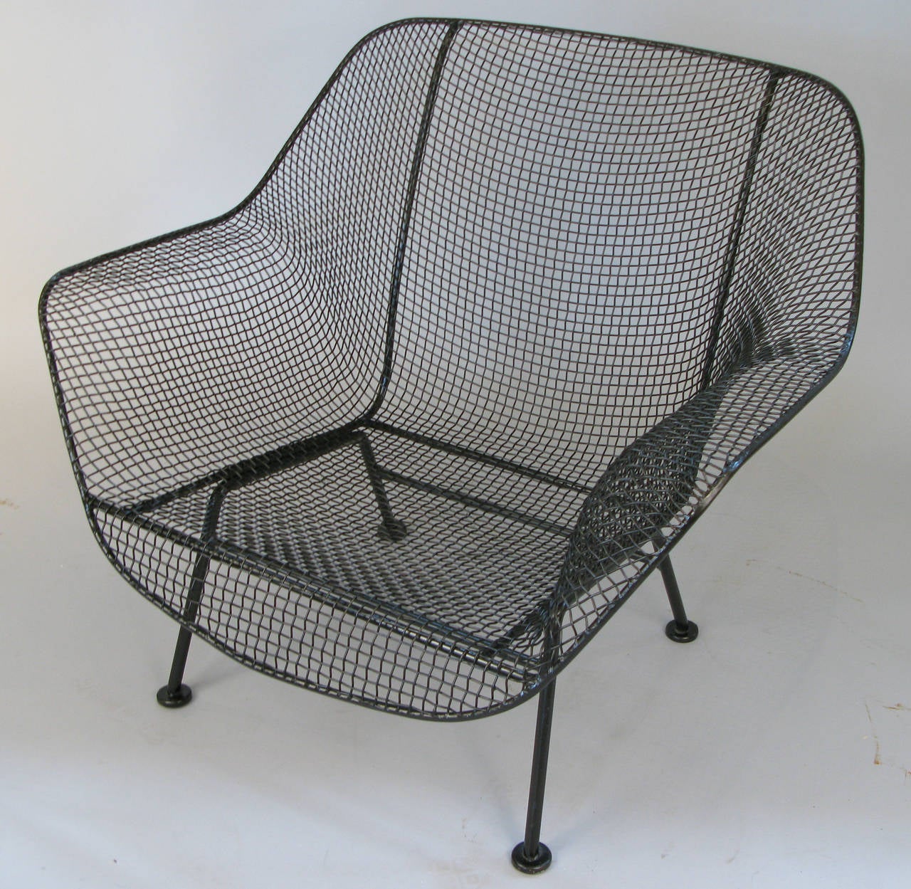 A pair of Russell Woodard's iconic Sculptura lounge chairs in wrought iron and woven steel mesh. Beautiful proportions in these wide and deep lounge chairs make them very comfortable and stylish. Finished in satin black, or can be finished in color