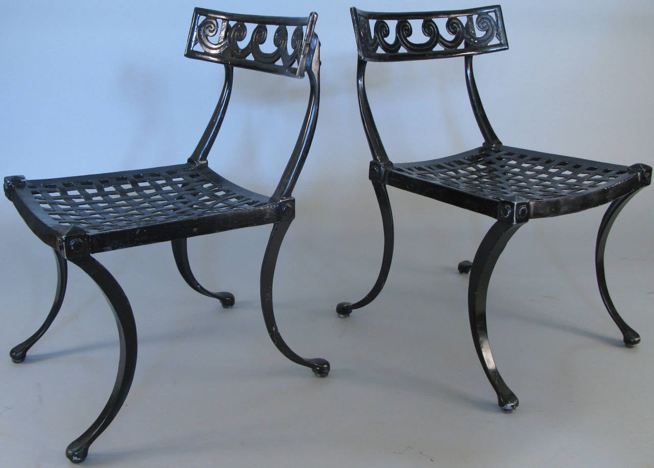 A pair of wonderful 1950s Klismos chairs in cast aluminum with lattice seats and curved backs with a vitruvian scroll design by Thinline. Beautiful scale and details.