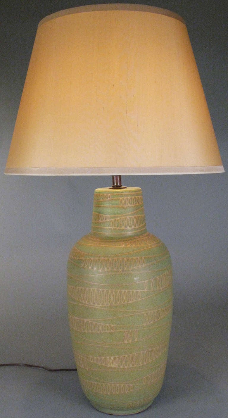 A beautiful vintage 1950 ceramic lamp by Design Technics, incised with an abstracted modulated wave pattern and finished in a pale green matte glaze. Mint condition. Shade not included.