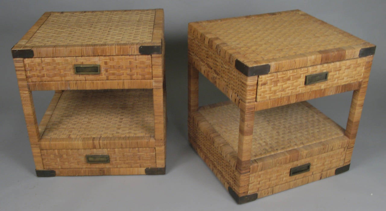 A charming pair of vintage mid-20th century nightstands finished entirely in woven rattan, with brass corner plates having a very nice patina. Two drawers each with original brass hardware. very nice scale and proportions.