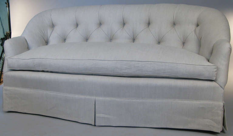 Very nice vintage button tufted curve back sofa originally from the estate of Brook Astor, just reupholstered in a grey linen, with a full down seat cushion.