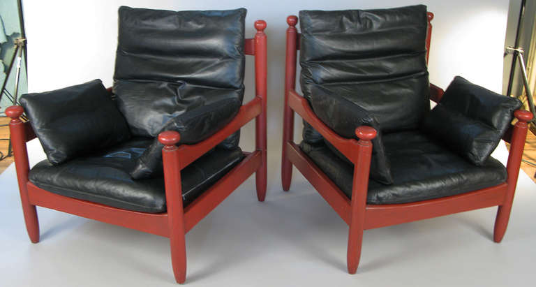 Handsome pair of vintage mid-century danish oak lounge chairs in red finish with original black leather loose cushions. comfortable and in excellent condition with great patina on the leather.