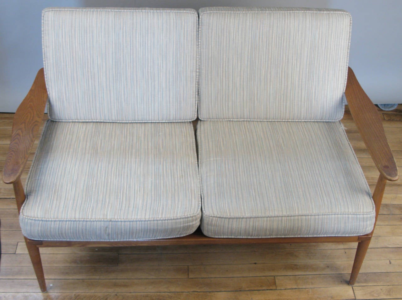 A Classic modern 1960s Danish settee in oak, with its original cushions. We have the companion lounge chair as well.