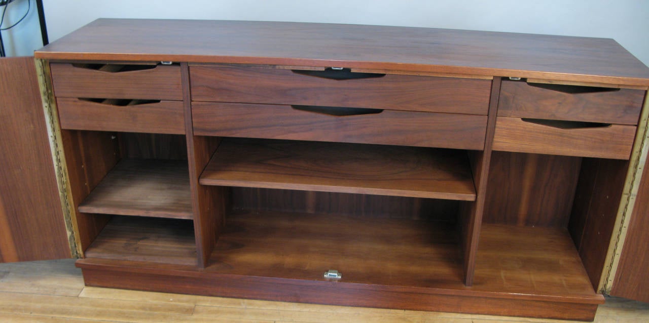 A very handsome vintage 1950s cabinet in beautifully grained walnut, with a pair of folding doors and an interior fitted with drawers and adjustable shelves. 
Very nice scale and details.