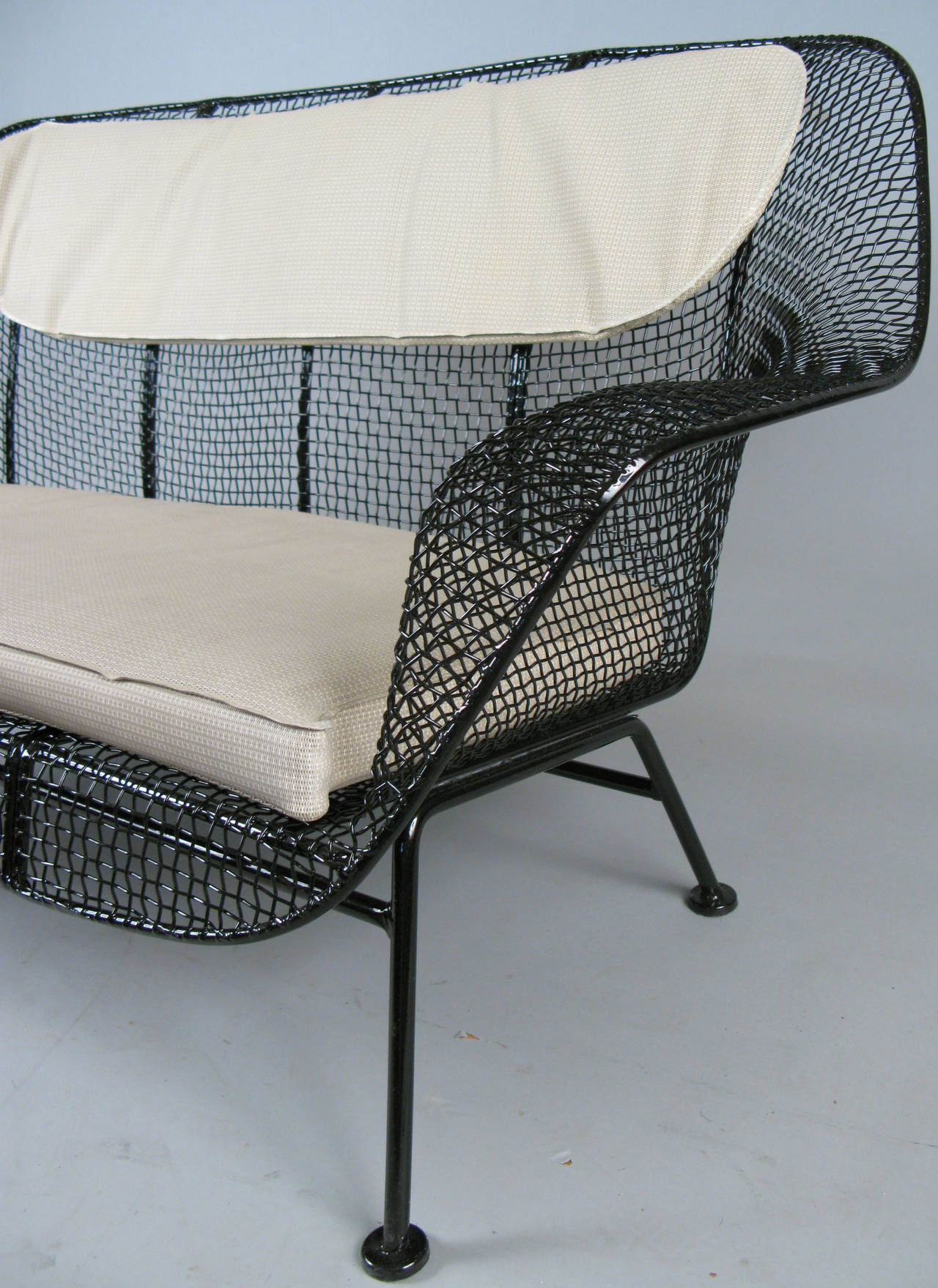 A vintage 1950s wrought iron and steel mesh settee from Russell Woodard's Classic and iconic Sculptura series. Beautiful and Classic sculptural design, finished in black. Cushions not included but can be custom ordered.

We also have Sculptura