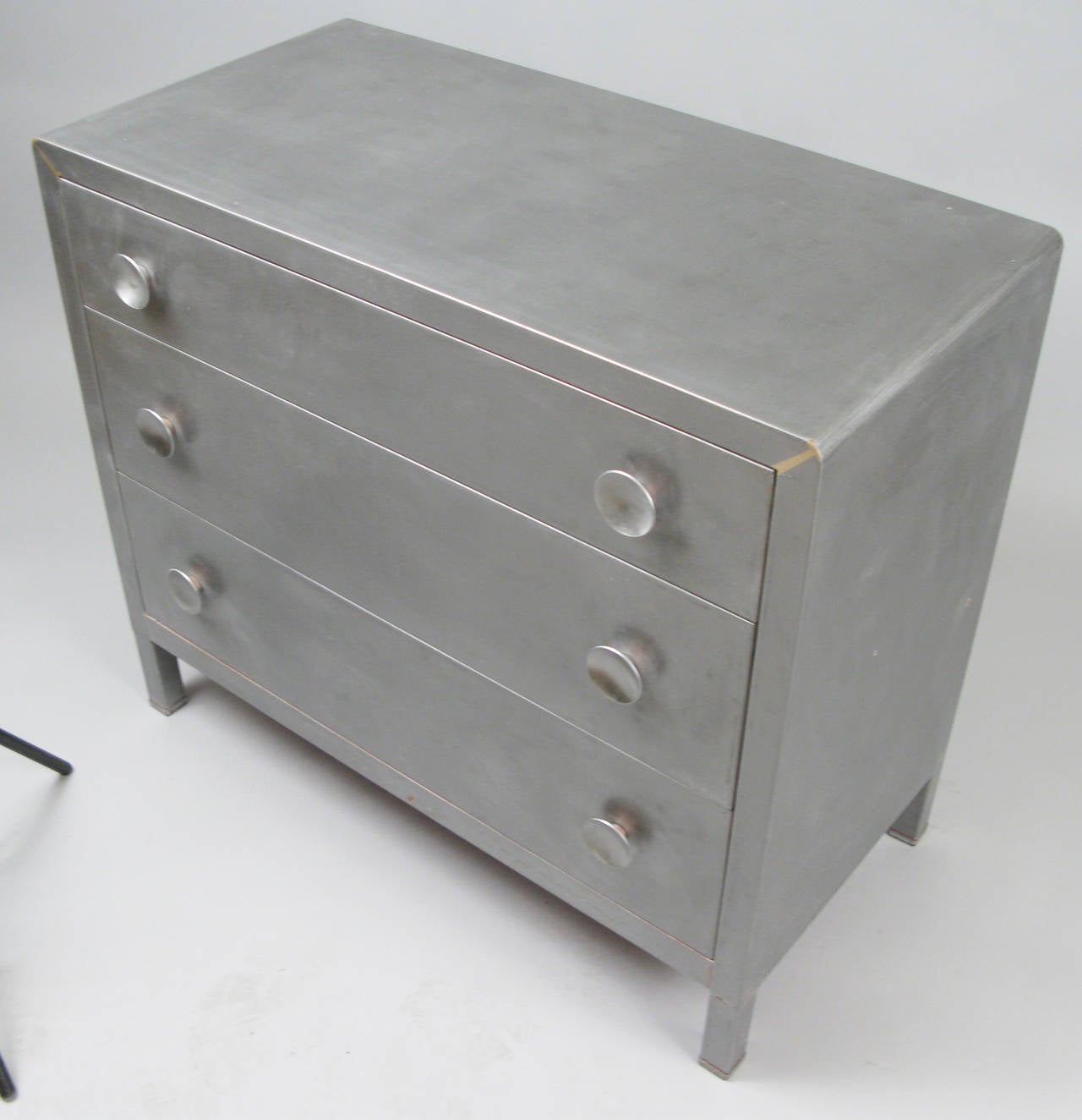 a very handsome vintage 1930's three drawer chest designed by Norman Bel Geddes for Simmons Furniture. classic art deco styling, beautifully stripped down to brushed steel.