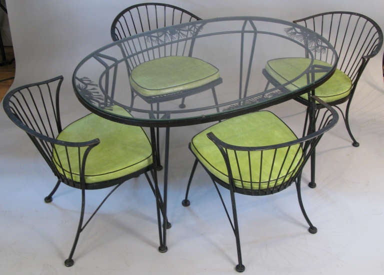 a classic and charming vintage 1950's wrought iron dining set by Woodard. 'Pinecrest' is one of woodard's most enduring designs - the oval table has a skirt with pine cone and pine needle motifs. the curved back chairs are woodard's most comfortable