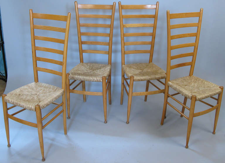 Nice set of four Italian ladder back chairs in beech with woven rush seats in the style of Gio Ponti. Very nicely made and sturdy chairs with great proportions. Marked made in Italy.