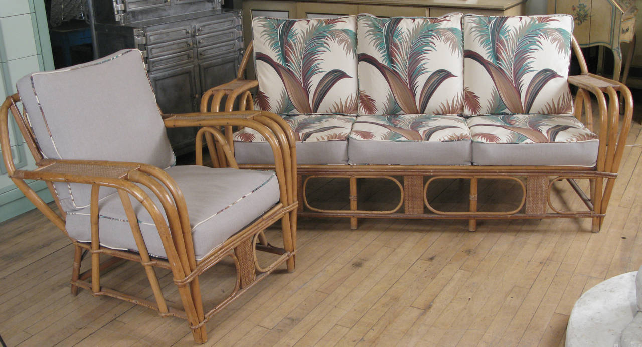 A charming vintage 1940s rattan lounge set, with a three-seat sofa and matching lounge chair, all with newly reupholstered cushions - one side has 'Hollywood Plumes', a Classic 1940s floral, and the other side is in greige natural linen. 

Sofa