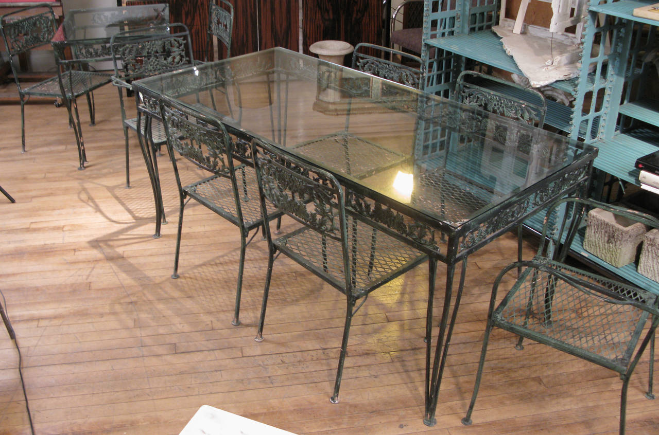 A beautiful large vintage 1950s wrought iron garden set by Molla, with a large rectangular glass top table and eight matching chairs. The set also includes a companion small glass top table, which is the same height and width as the larger table.