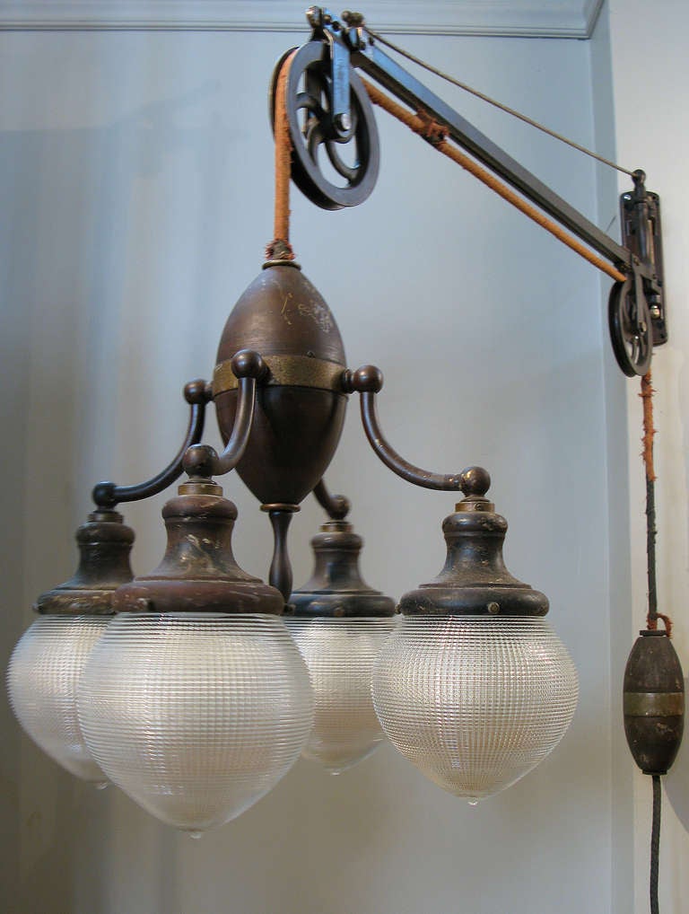 a rare find - this antique lamp was originally a dentists lamp, with an iron wall bracket supporting an adjustable telescoping arm with the original wheels which hold the 4 light cluster lamp with the original shades. the height adjustable lamp is