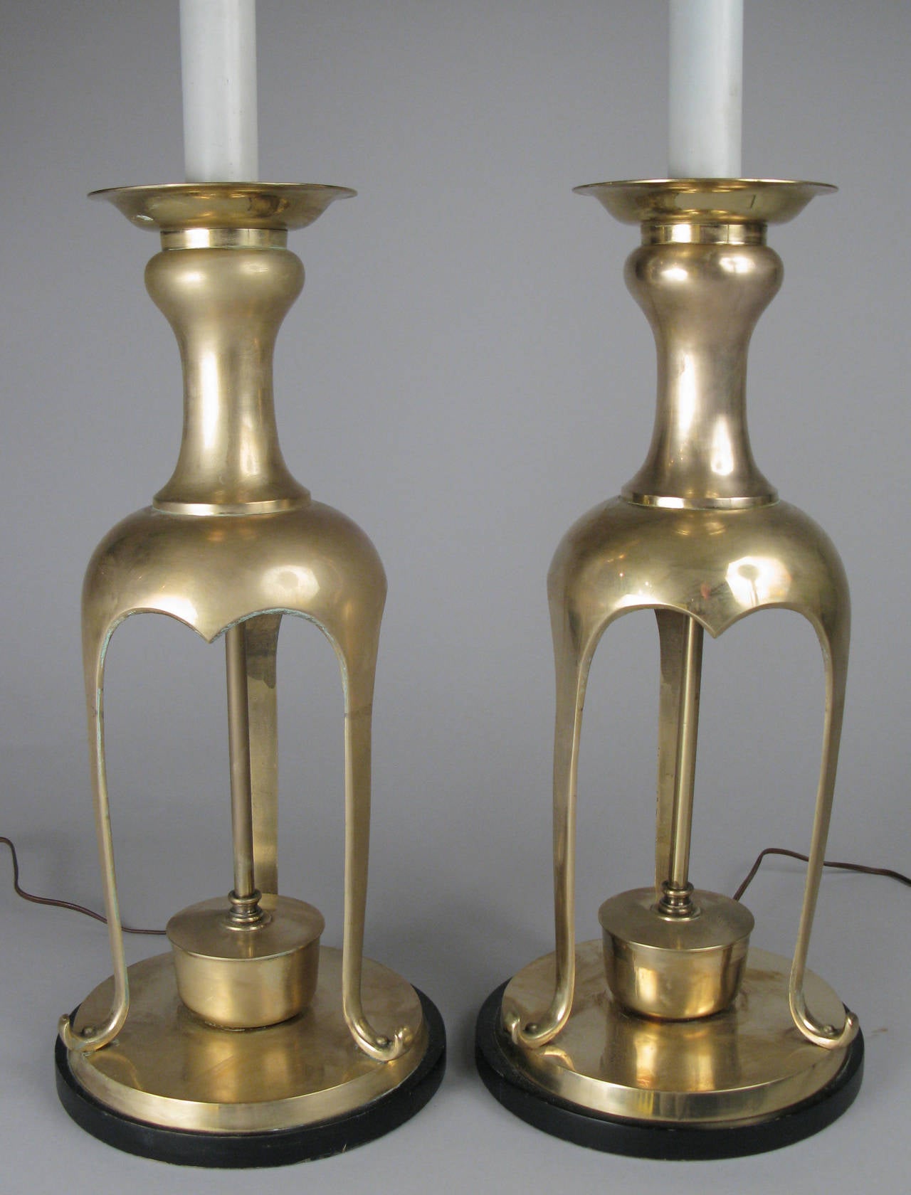 A very large-scale pair of 1960s Asian Modern altar stick lamps in solid brass, with lacquered wood stems and double sockets, with their original ring finials.