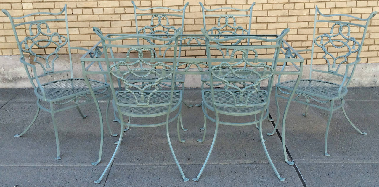 One of the most beautiful and charming vintage wrought iron dining sets by Salterini, this Rope and Tassel set has six chairs and the matching rectangular table which gets a glass top. The table and chairs are incredibly well made and the details