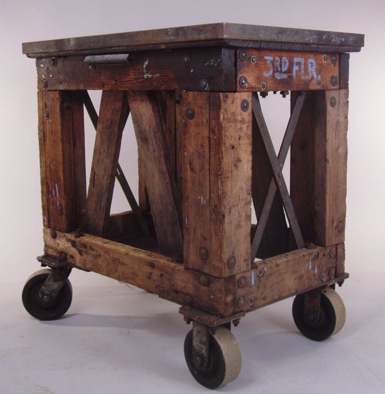 a very handsome tall form antique industrial rolling cart. great form with wood X stretchers on the long sides, and steel X stretchers on the ends. iron band around the zinc top. cast iron wheels, 2 of which turn to make it easy to move around.