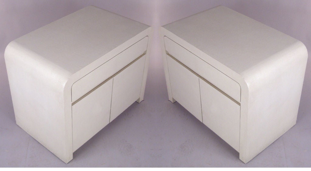 a very nice pair of vintage 1970's nightstands covered in Linen. hinged doors conceal an adjutable shelf, with a single drawer above. wonderful classic design.