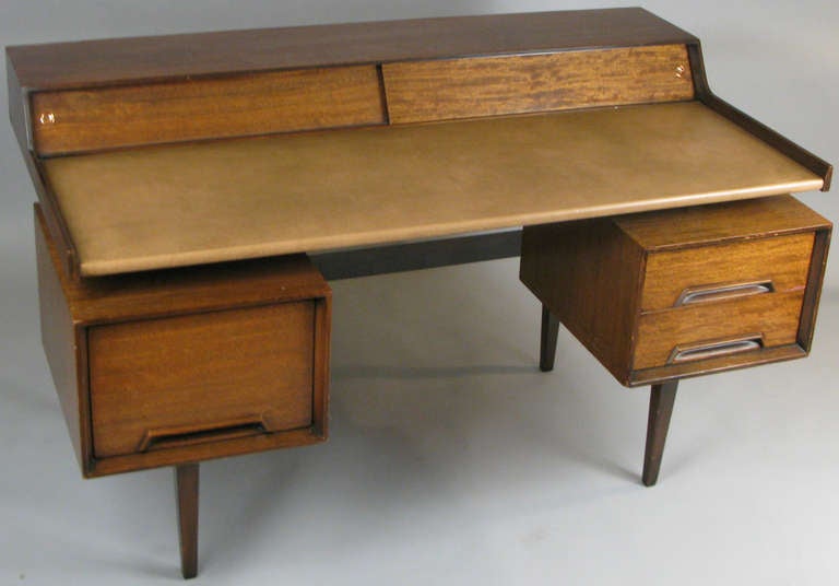 a very handsome vintage 1950's desk designed by John van Koert for Drexel. designed with a leather writing surface floating above a pair of storage compartments, one with angled file storage. the top with a raised portion with sliding doors