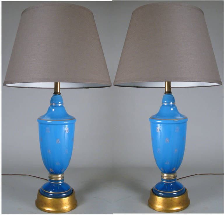 A pair of very charming 1960s table lamps by Frederick Cooper with stunning bases of royal blue glass with gold leaf bases, having small gold leaf bees decorating the blue glass.