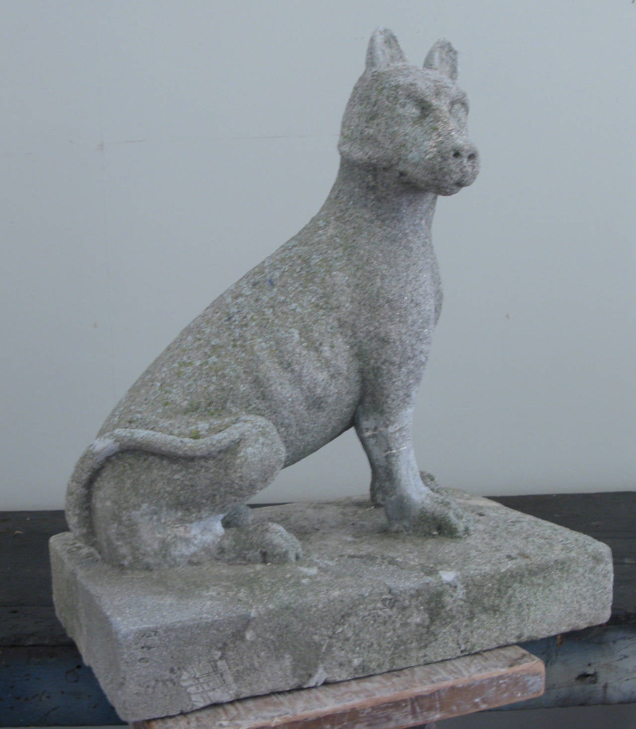 a very sweet 1930s cast stone figure of a seated dog, on a rectangular base, with some repairs as shown.