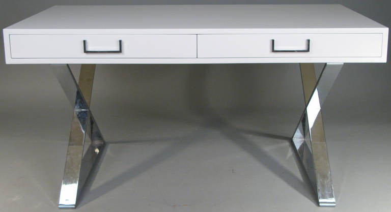 Un bureau classique et moderne des années 1970 avec des bases en X chromées et un caisson à deux tiroirs en laque blanche satinée:: avec des ferrures chromées à charnières.
