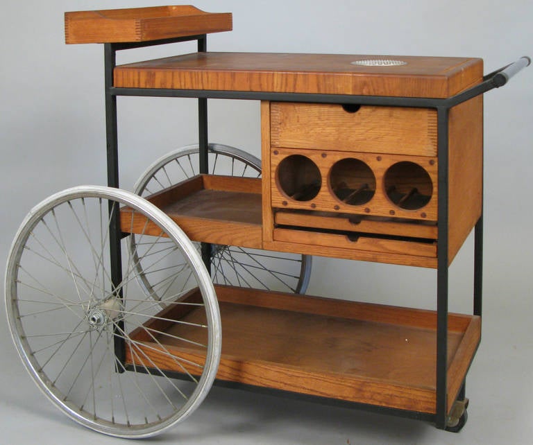 a rare 1950s rolling bar cart designed by Arthur Umanoff, all original with oak butcher-block top inset with citrus cutting disc, double sided bottle storage, sliding drawers, and the original bicycle wheels. a fine example of this rare piece.