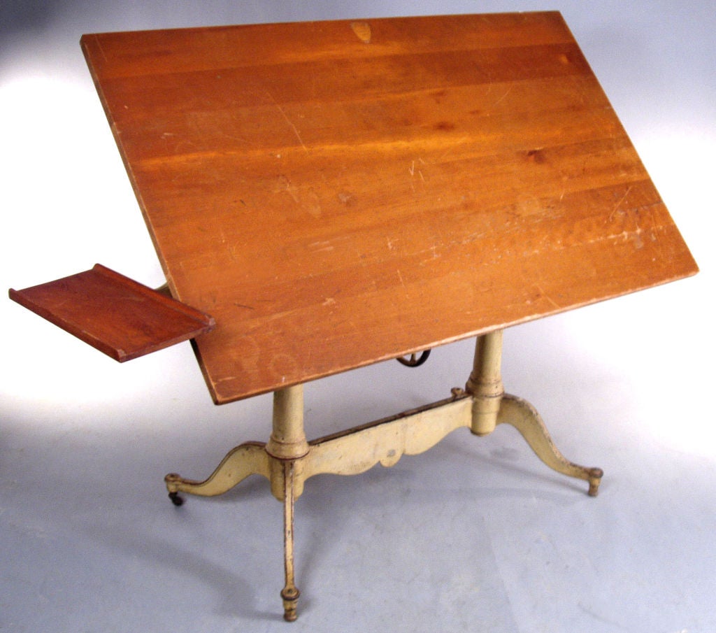 an outstanding antique Keuffel & Esser drafting table. this is one of their best. the scalloped edge cast iron base having split sides with 4 legs, the rear ones having steel casters. the tabletop has a height adjustment with a cast iron wheel in