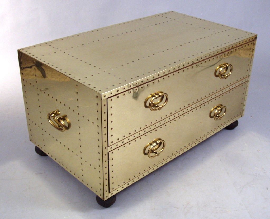 a very nice classic vintage 1970's chest by Sarreid. the case in wood completely covered in brass with copper nails. solid brass handles on the drawers and the sides of the chest. perfect as a cocktail table or nightstand.