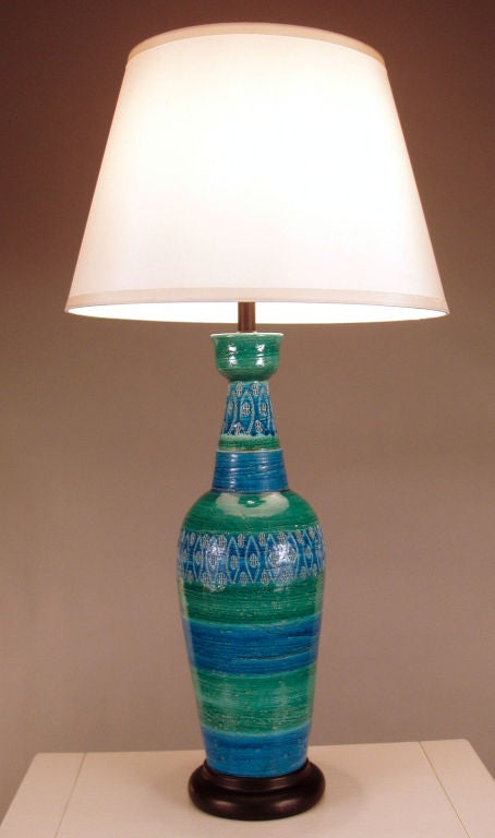 a beautiful tall form glazed ceramic lamp circa 1950, finished in great shades of blue and green, and incised with geometric patterns. mounted on a steel base. gorgeous form and color. mint condition.