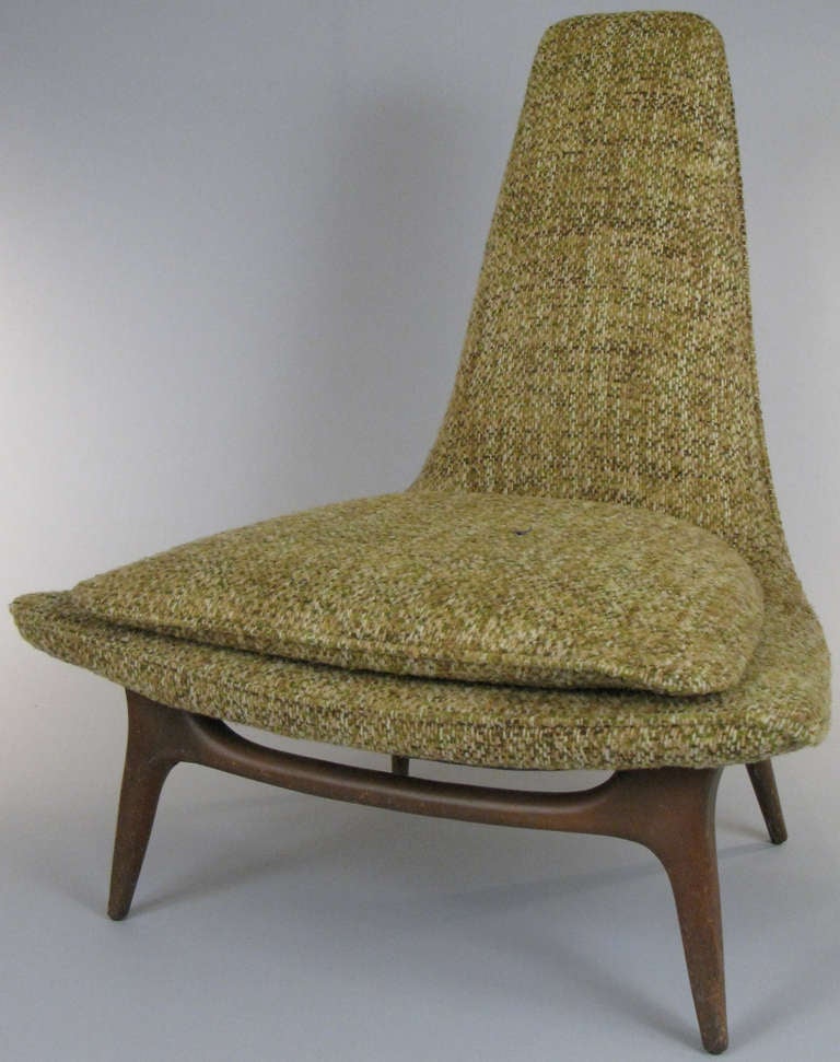 a dynamic high back 1950's lounge chair by Karpen. raised on a beautifully sculpted walnut base. in a textured woven fabric.