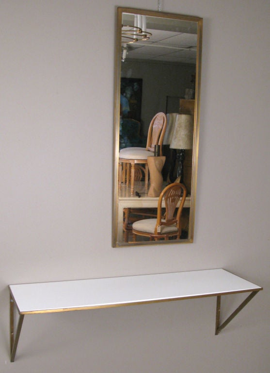 a very nice vintage 1950's wall mounted console table and matching mirror both with square brass frame with a white glass shelf. very nice classic modern design perfect for entry or bath. <br />
<br />
console is 36.5