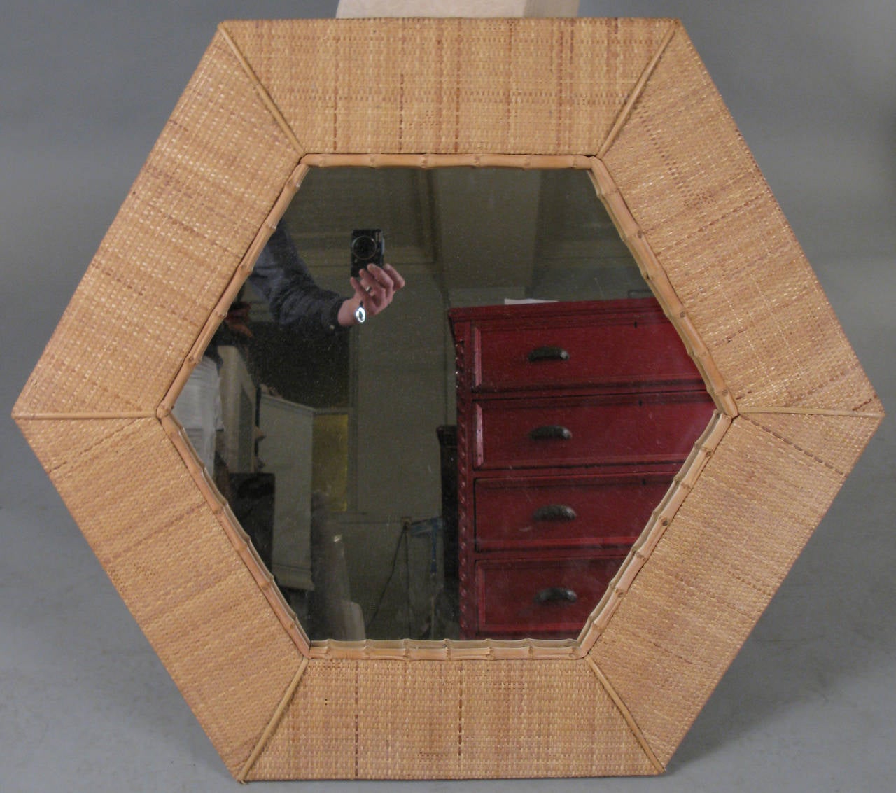 A very unique 1960s modern octagon-shaped mirror, with a wide border covered in woven rattan, with a bamboo border, made by Raymor.