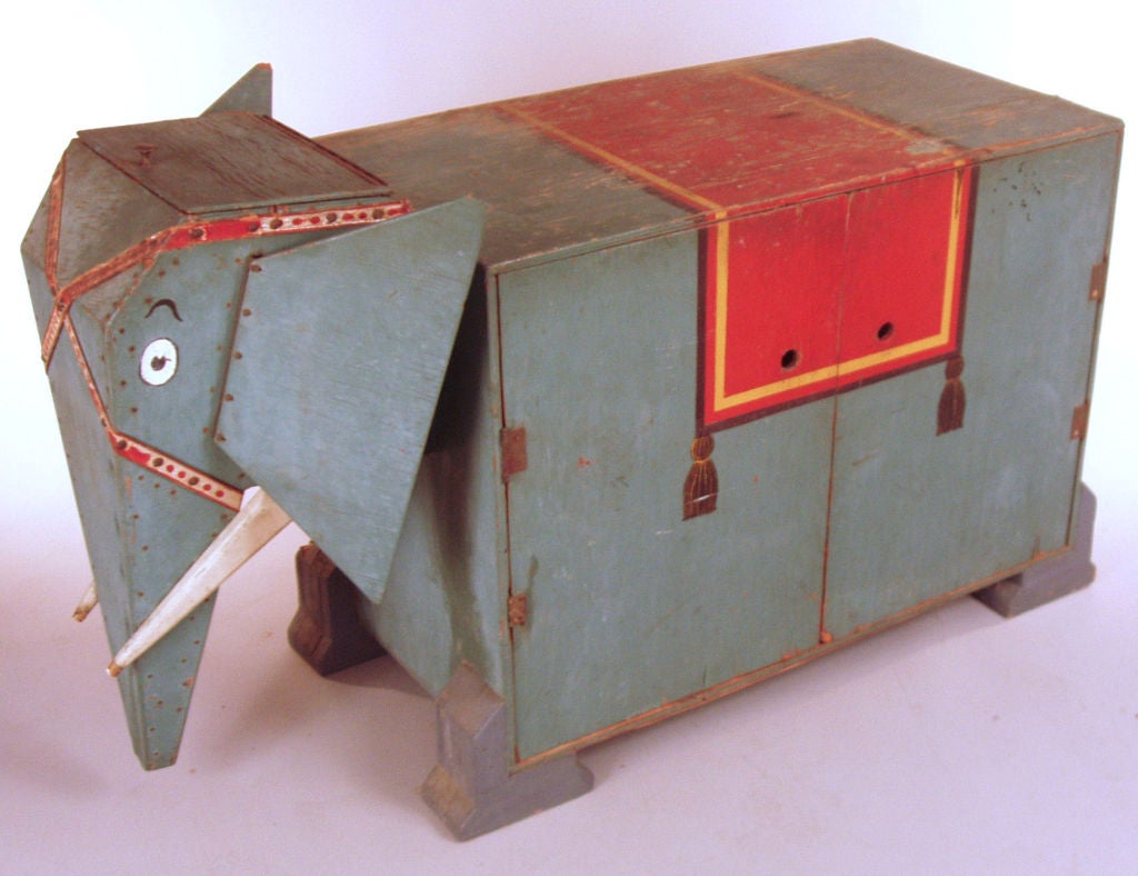 a charming antique handmade cabinet in the form of a circus elephant. wonderful details with original tusks, paint and harness. hinged moving ears, storage inside the head, and the body opens to reveal storage with charming paintings on the inside