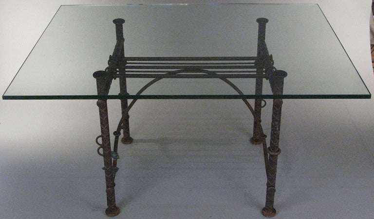 an outstanding forged iron table with bronze accents and glass top by Israeli artist Ilana Goor.

glass top is 58