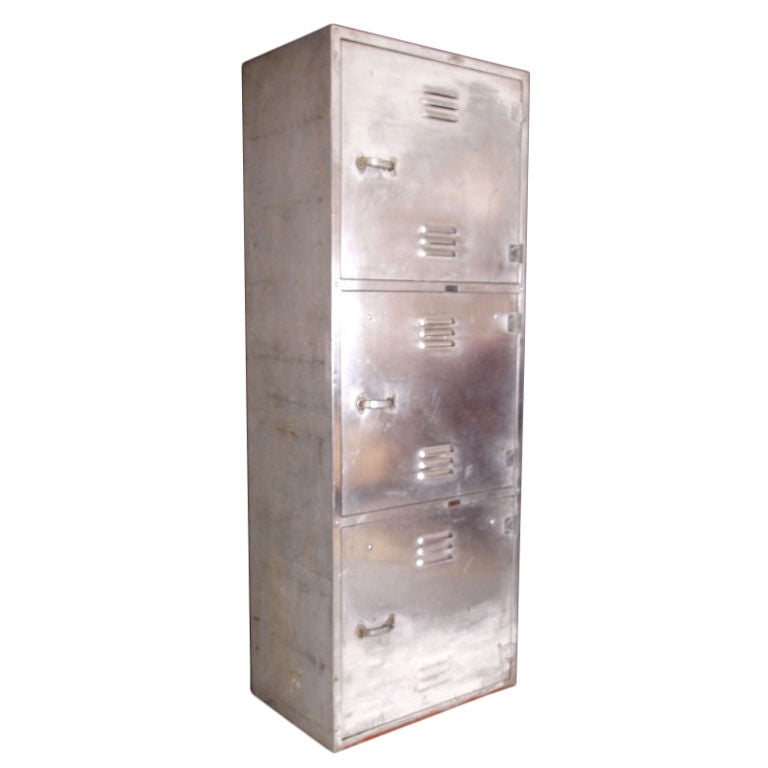 a vintage aircraft aluminum cabinet containing 3 lockers, each locking. the interiors of each are divided, and also contain a locking drawer. perfect for a variety of storage.